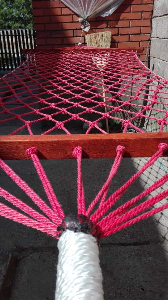 Detalj ručnog pletiva roze viseće mreže i čvorova